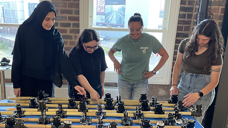 Madelyn Cruz and Bella Slosberg working with BCU students on the gateway structure.