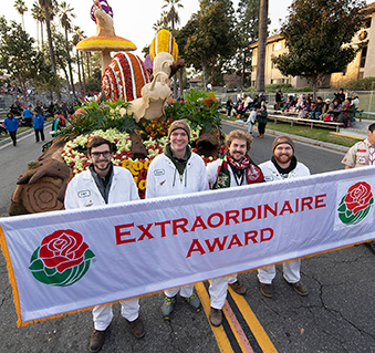 Rose Parade team members walk in front of the Cal Polyf parade float.