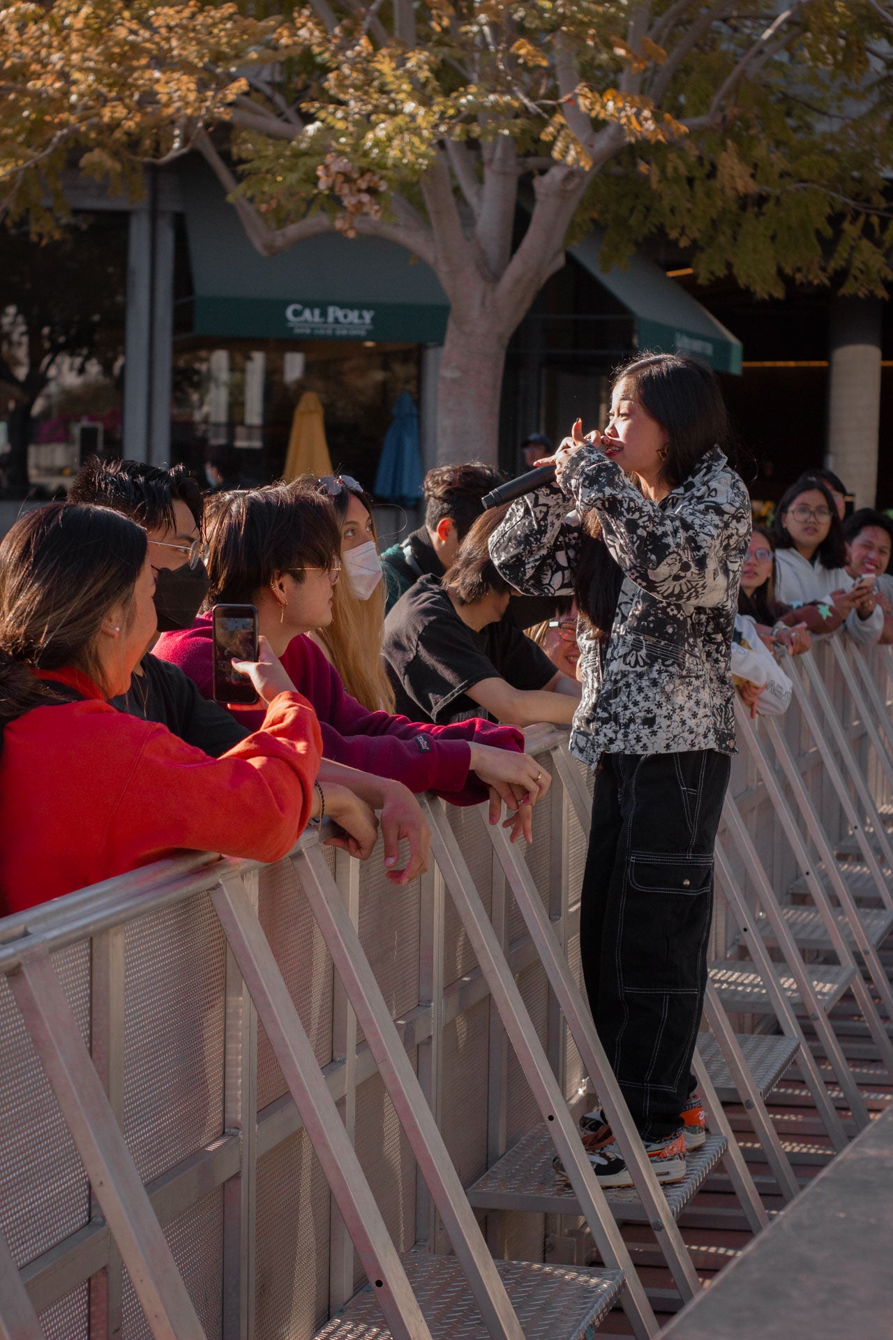 Ruby Ibarra, wearing a black and white jacket, singing alongside concert-goers Ruby Ibarra, wearing a black and white jacket, singing alongside concert-goers