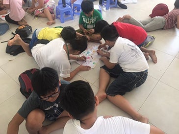 Mizuki creating a poster with students at Tam Ha School.