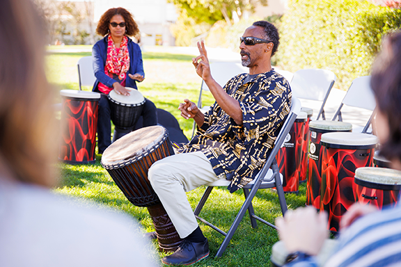 Teach In attendees participate in a drum circle