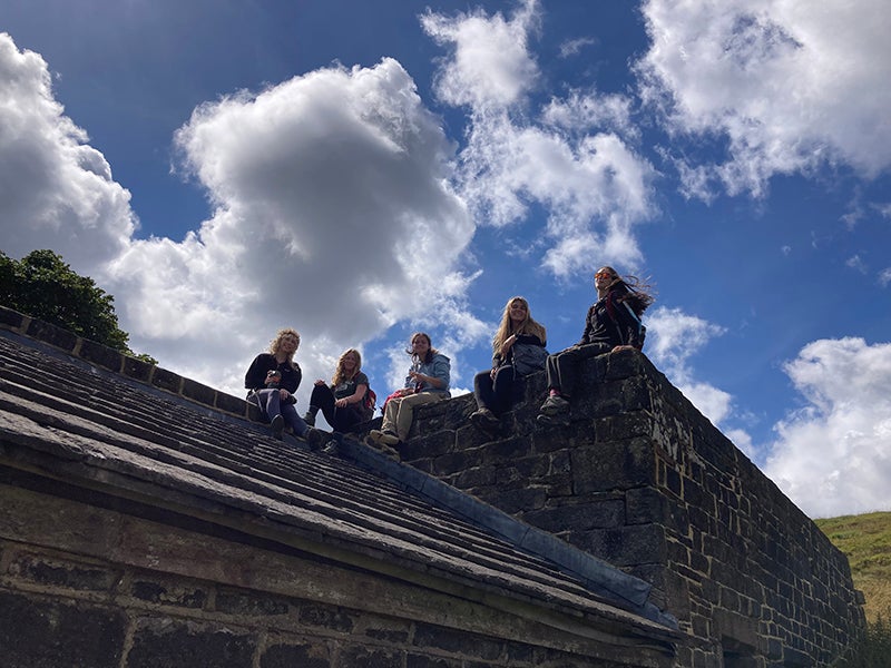 Students sit on the farm house