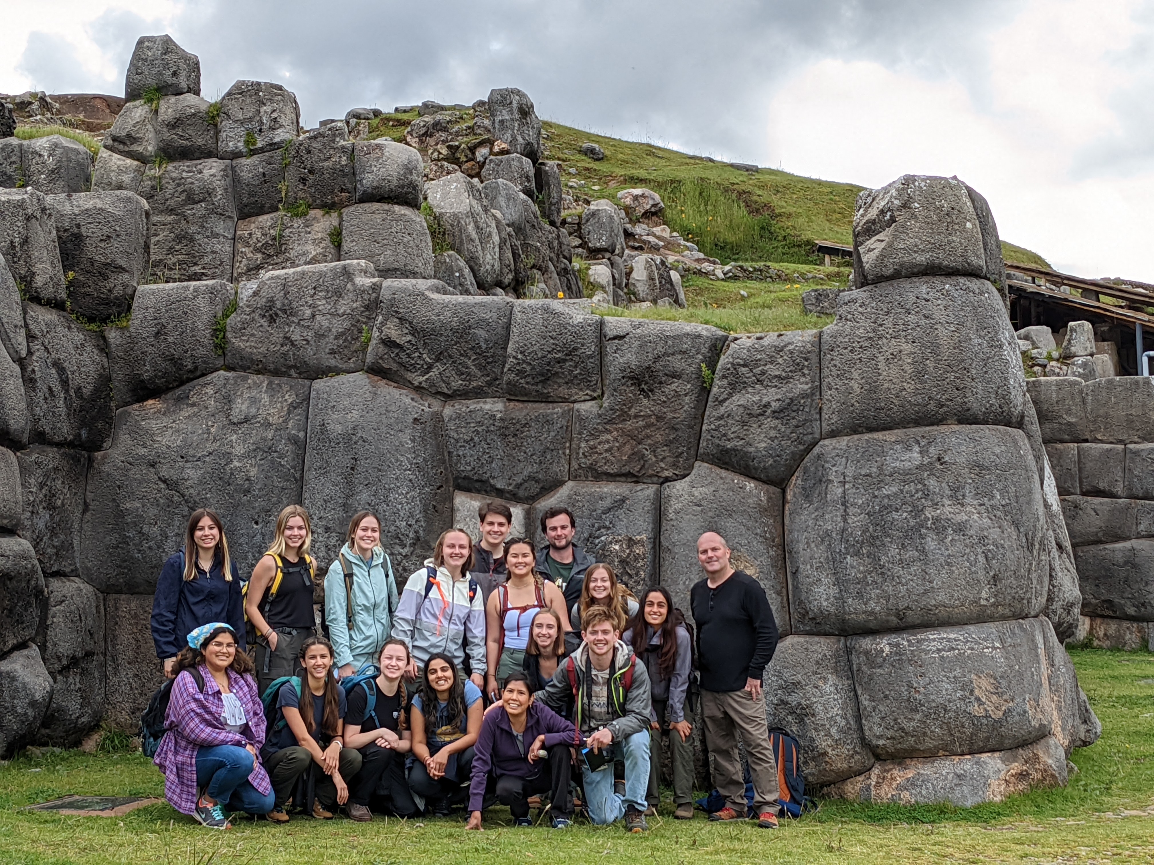 The group poses in front of the Sacsayhuaman Incan ruins.