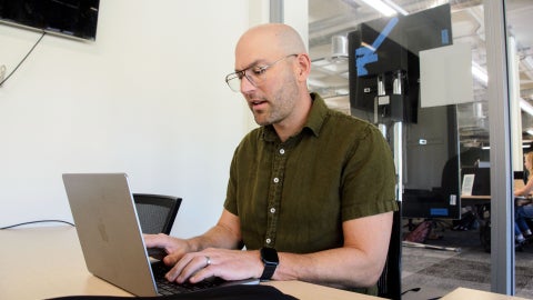 Professor Matt Harsh working on a laptop at Kennedy Library