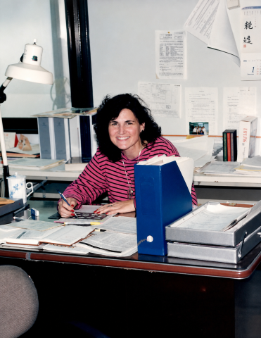 Woman at a an office desk with documents on it