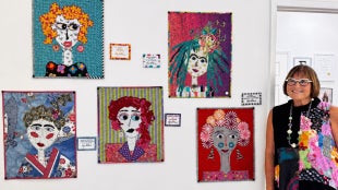 Lynn Davis poses next to artwork on a white wall