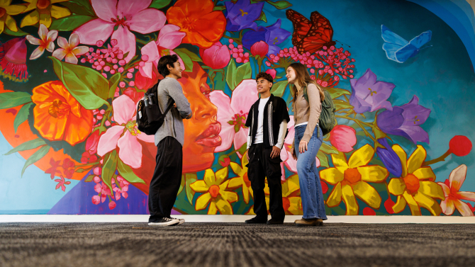 Students standing in front of flower mural