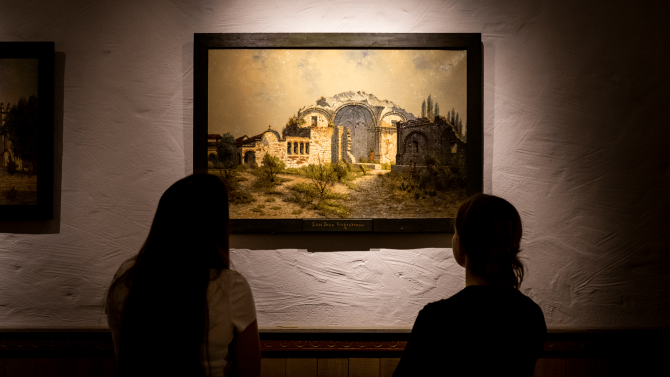 Two students looking at a historical painting