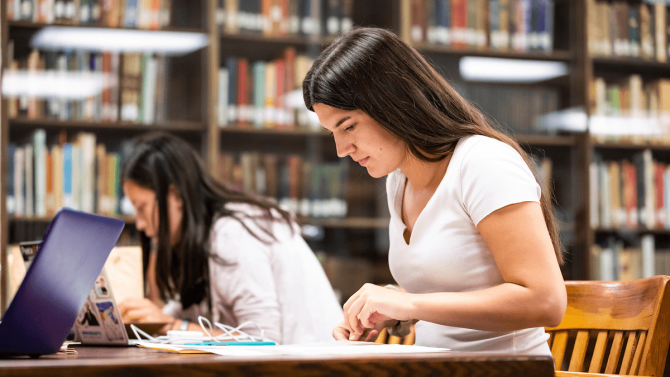 Student reading a book at a library