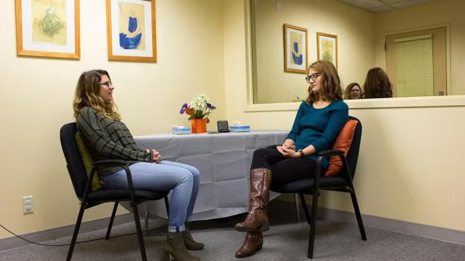 Two people sitting in front of each other talking