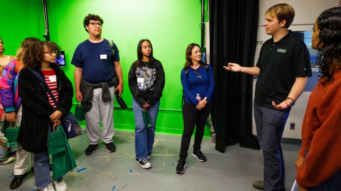 Journalism students in front of a green screen