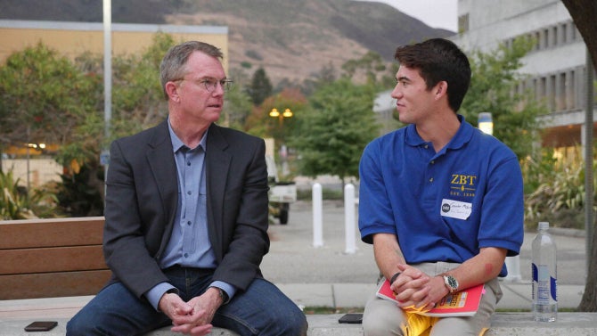 Cal Poly Journalism student sitting outside talking to mentor