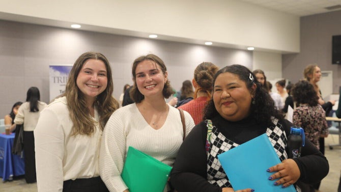 Thre students looking at the camera smiling